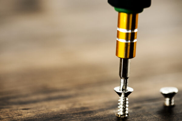 Drill and Screw on wooden background